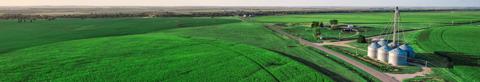 aerial view of green farmland and grain bins
