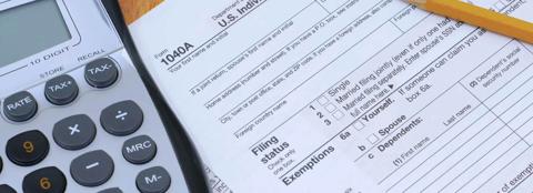 Close up of a 1040A form with a pencil and a calculator