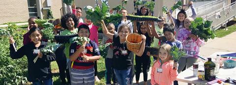 young children holding greens