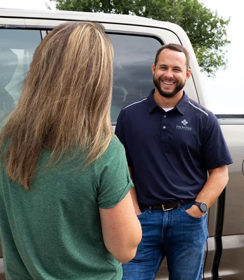 man and woman talking by a truck 