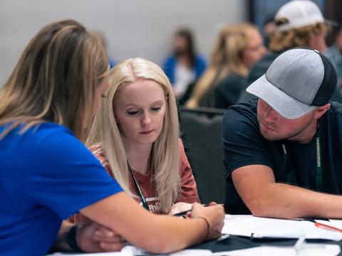 Two people looking at a piece of paper with an advisor