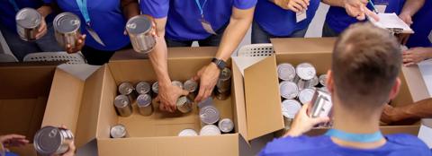 group of people packing can in boxes