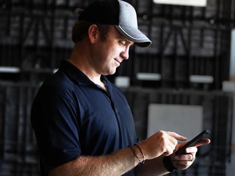 man looking at phone in a shed