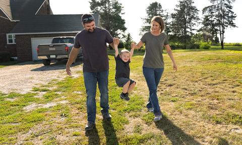 farmers outside at rural home with son