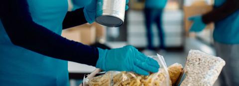 volunteer wearing gloves packing food to be distributed