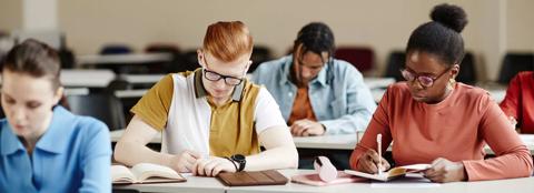 students in class writing in notebooks 