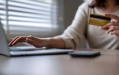 woman making a purchase with her credit card on a laptop.