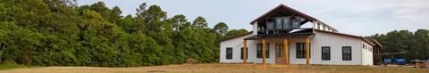 white barndominium nestled between trees